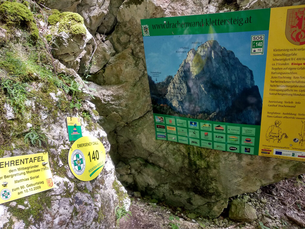 tablice informacyjne, w tym zawierające numer alarmowy, przed wejściem na via ferratę Drachenwand